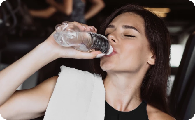 Mulher bebendo água durante treino